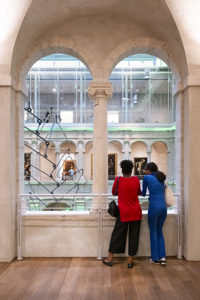 Two women overlooking a balcony at the Harvard Art Museums.