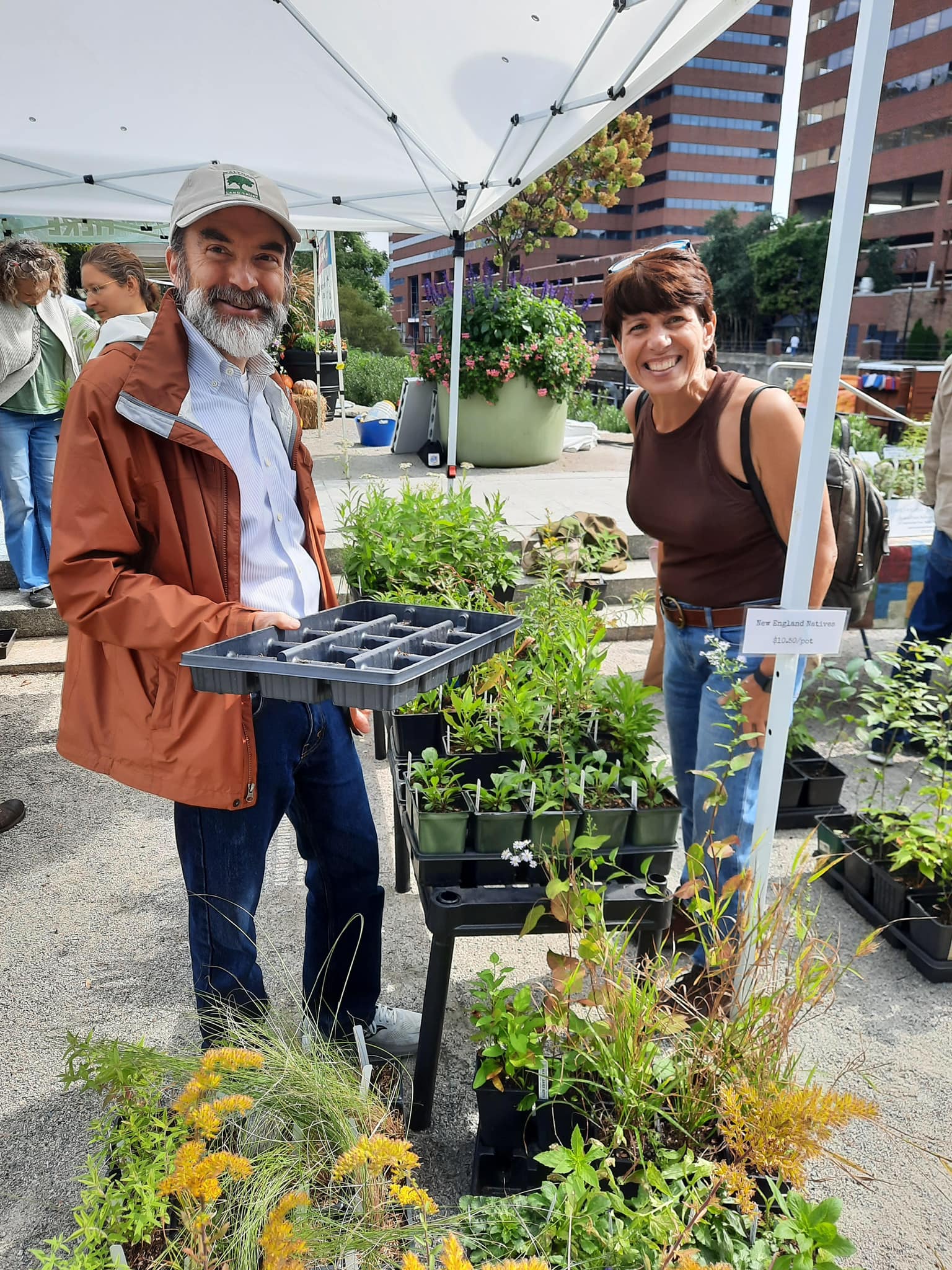People showing off plants at Kendall Square Farmers Market.