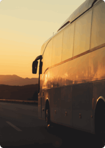 A bus from Boston's South Station is bound for Cambridge, MA. A golden sunset reflects off the bus's side panel.