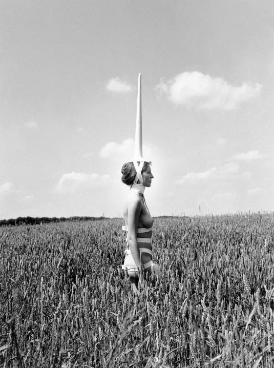 A black-and-white photograph of a woman with a horn on her head.
