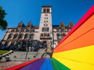 Cambridge City Hall with a rainbow pride bench out front.