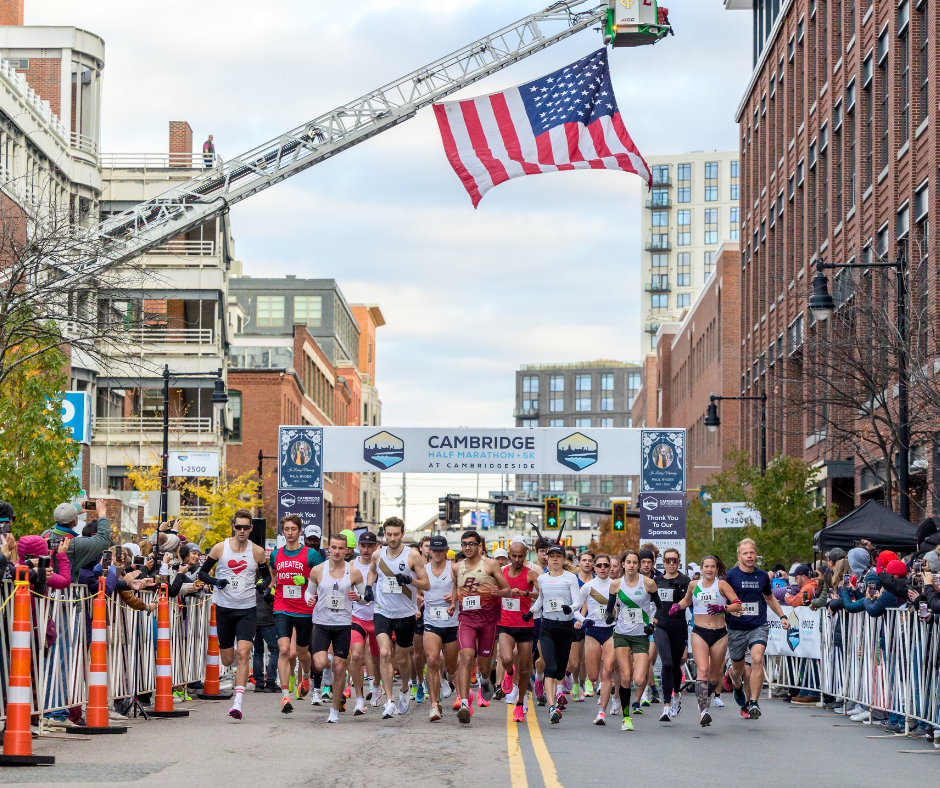 People running under an American flag.